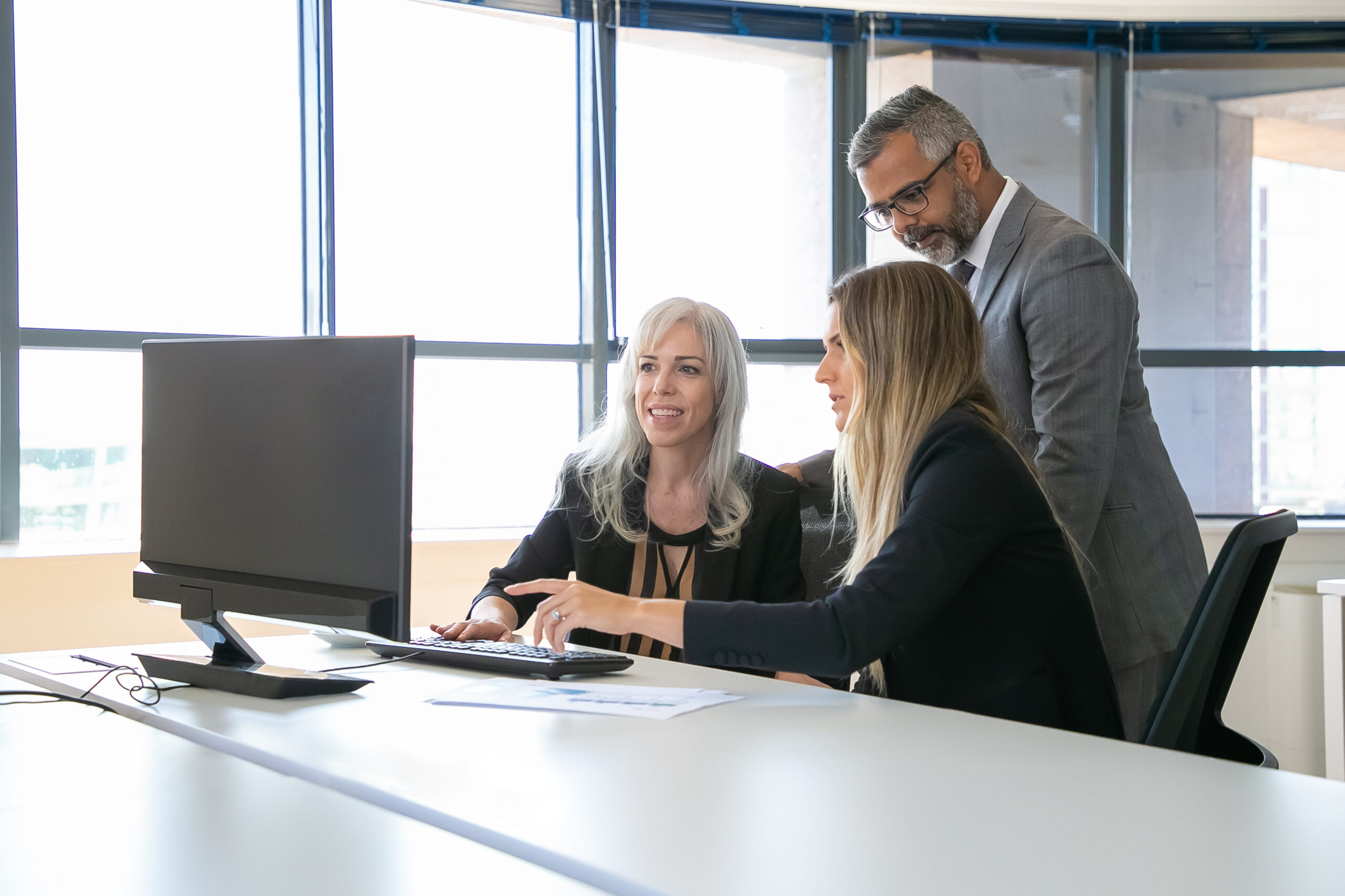 positive business colleagues watching presentation pc monitor discussing project sitting workplace pointing display business communication concept scaled